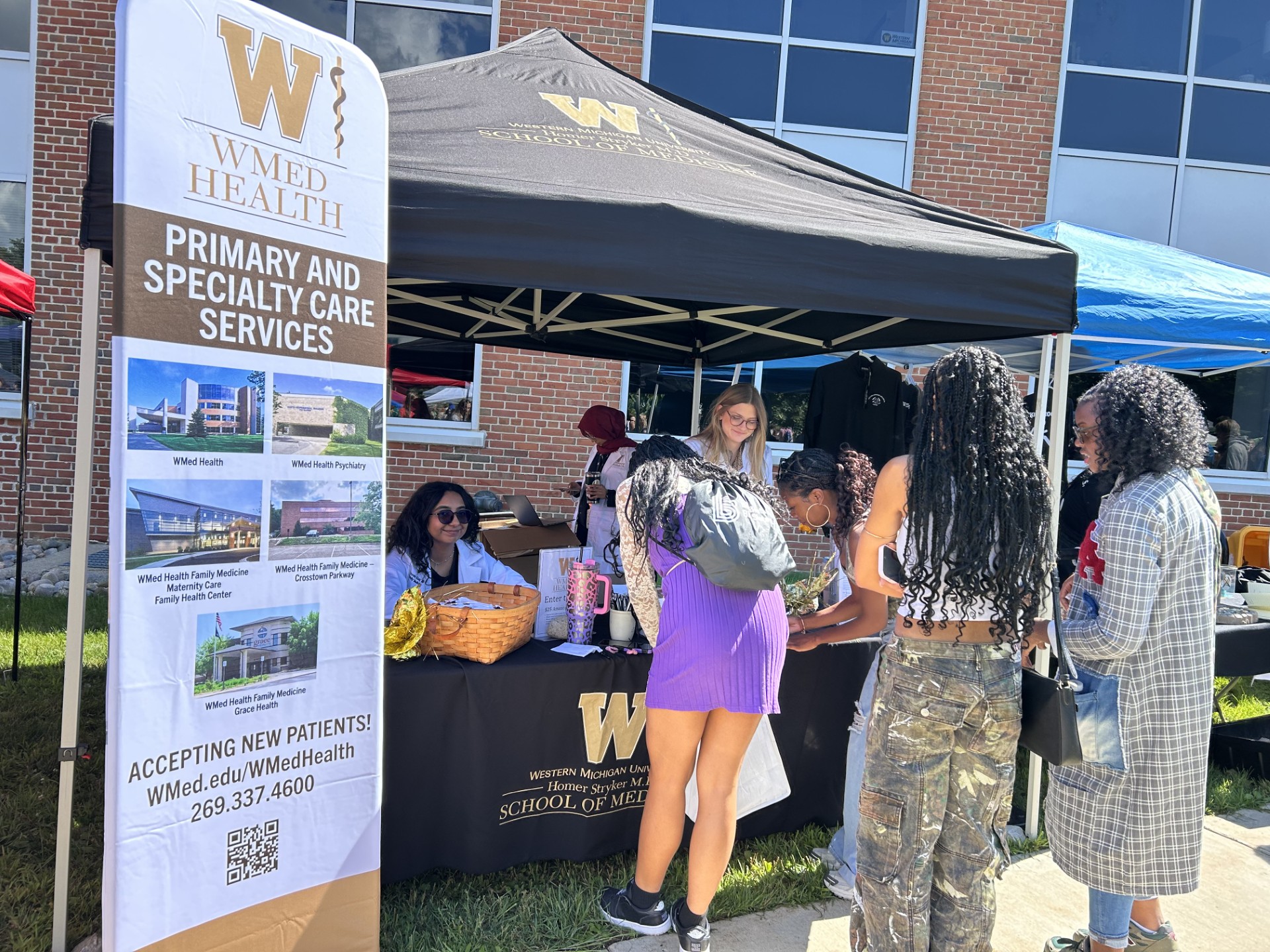 Photo of students visiting the WMed Health booth at Bronco Bash