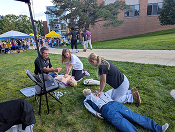 Photo of WMU students participating in a hands-only CPR challenge during Bronco Bash