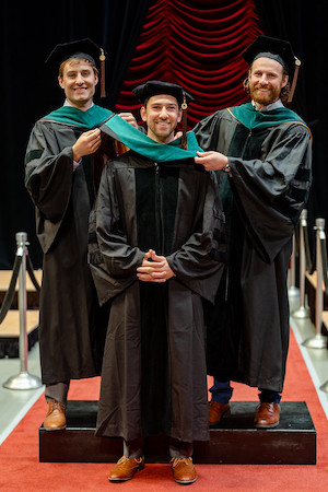 Drs. Jordan and Justin Jabara served as honorary hooders for their youngest brother, James, during his WMed commencement ceremony on May 11.