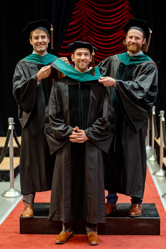 Drs. Jordan and Justin Jabara served as honorary hooders for their youngest brother, James, during his WMed commencement ceremony on May 11.